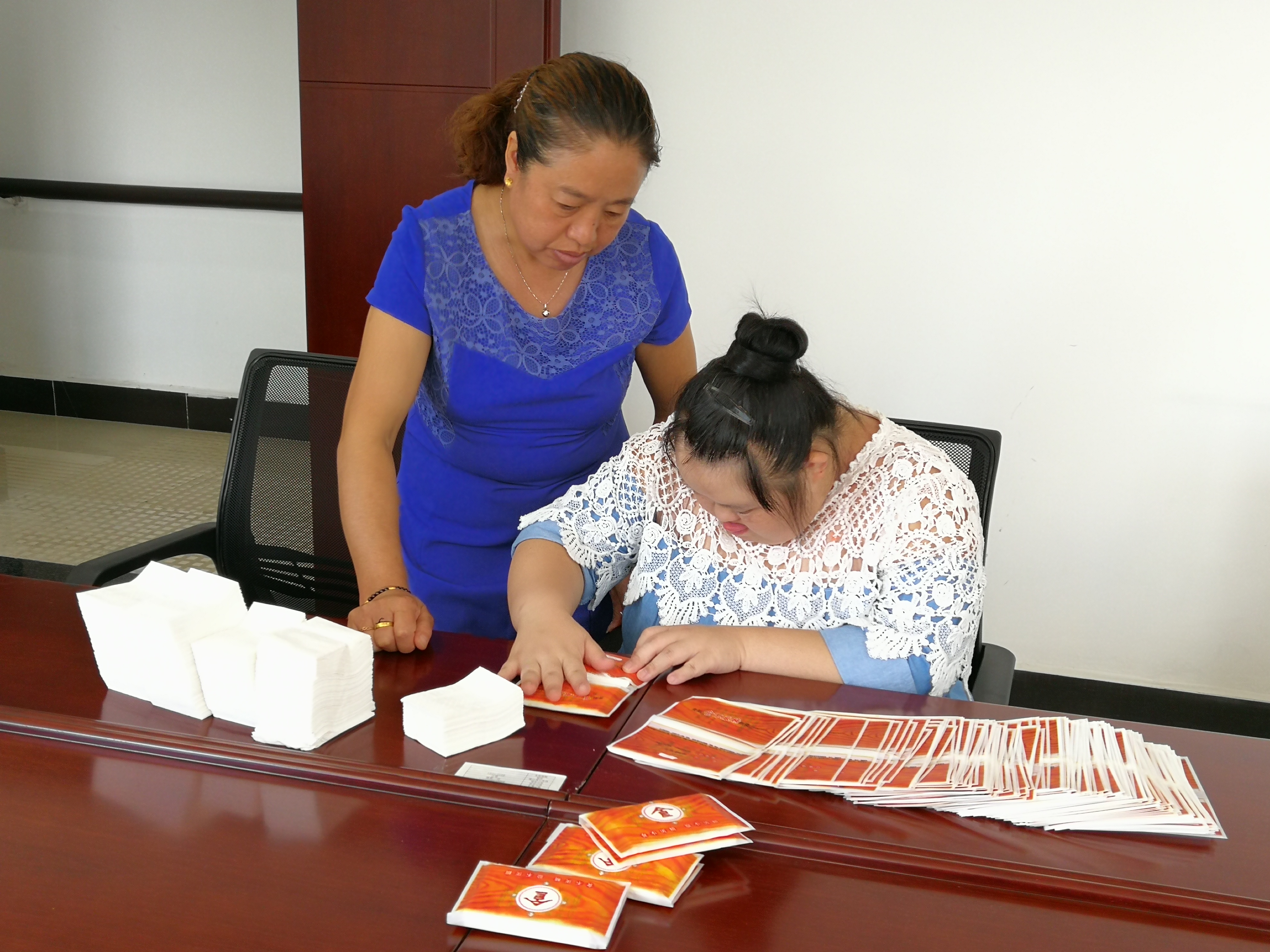 贵阳阳光生活用纸厂工人指导残疾人包装.jpg